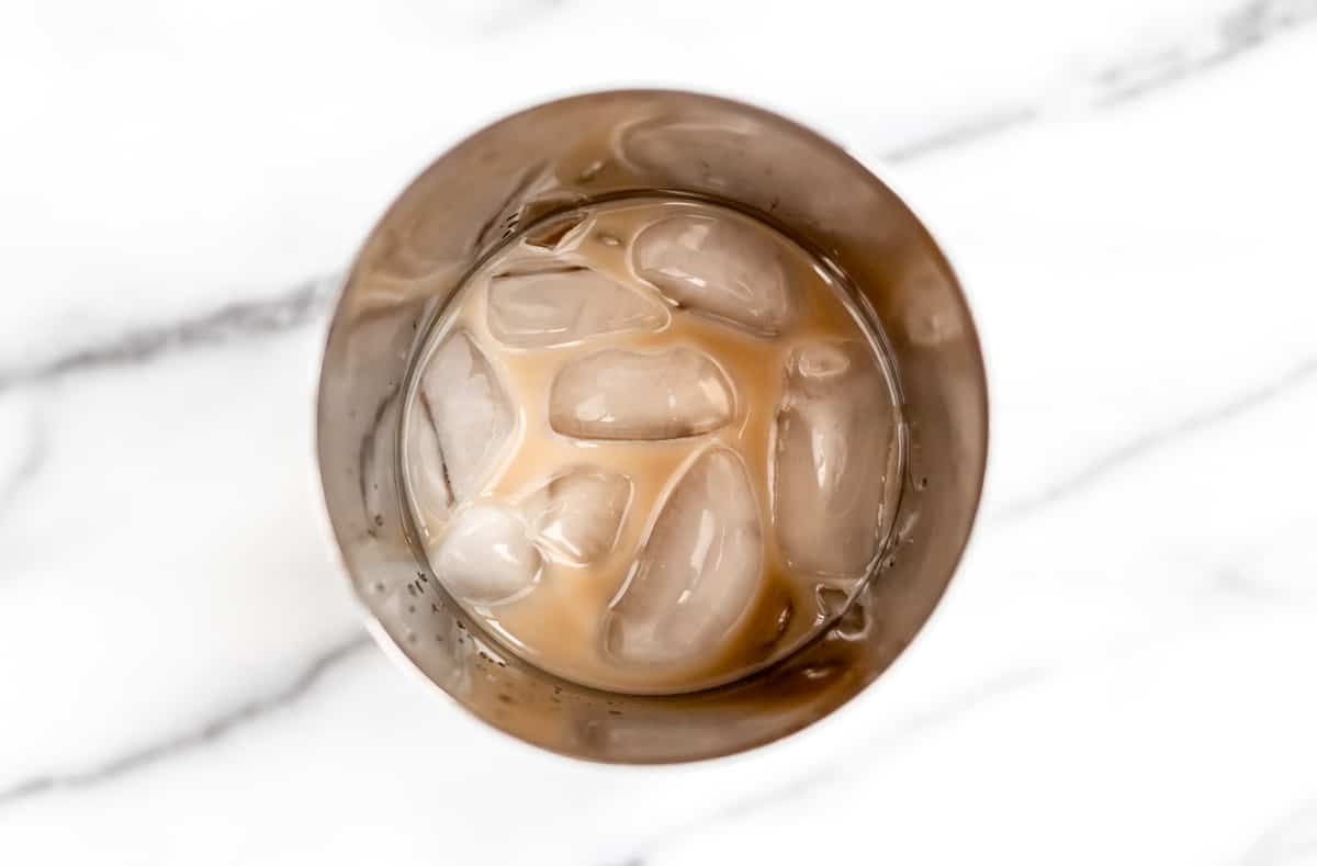 Alcohol and ice in a metal cocktail shaker.