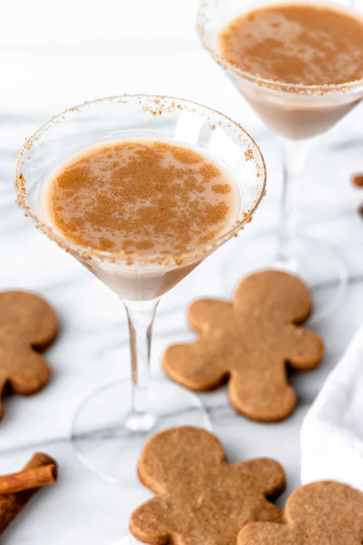 2 gingerbread martini cocktails with gingerbread men all around them.
