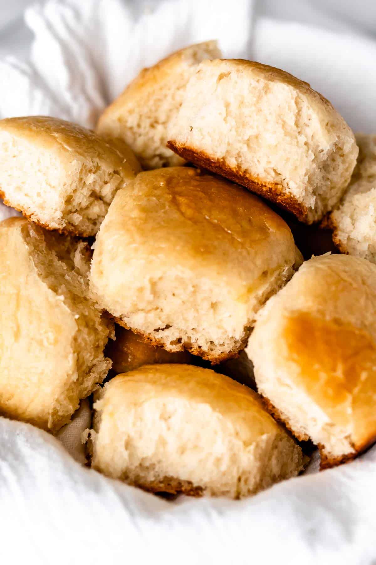 Close up of dinner rolls on a white towel.