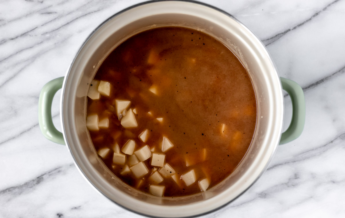 Stock and potatoes in a stock pot.