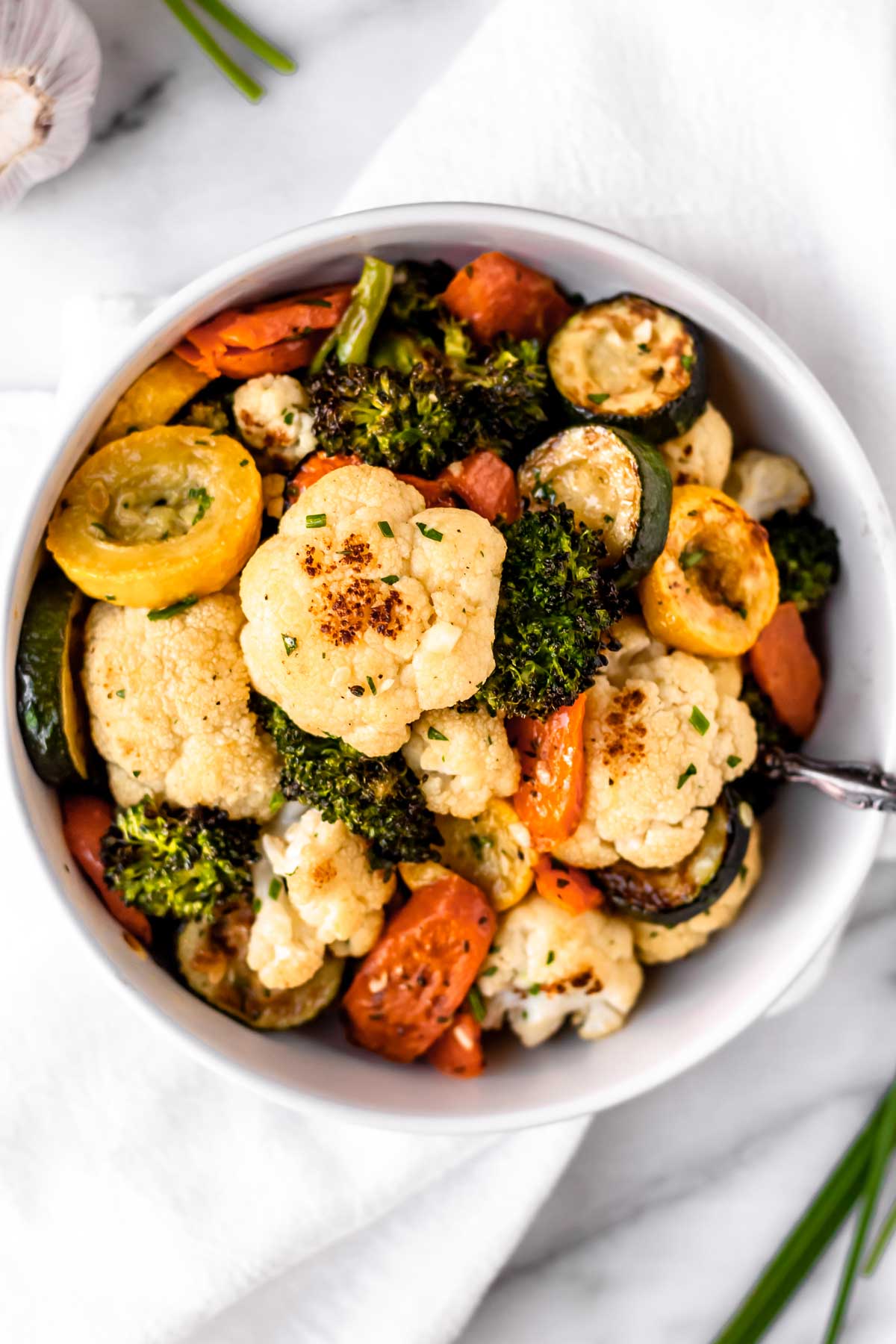 Overhead of normandy blend vegetables in a white bowl with spoon.