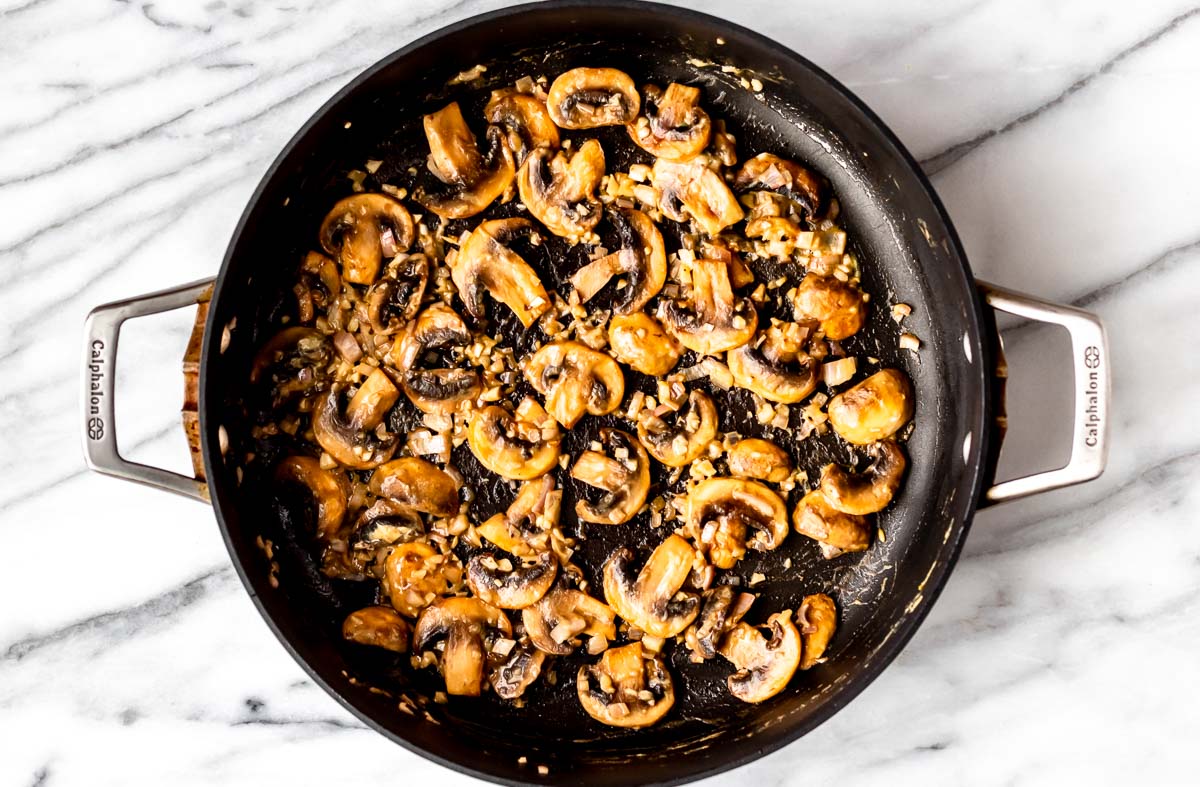 Mushrooms, shallots and garlic cooking in a skillet.