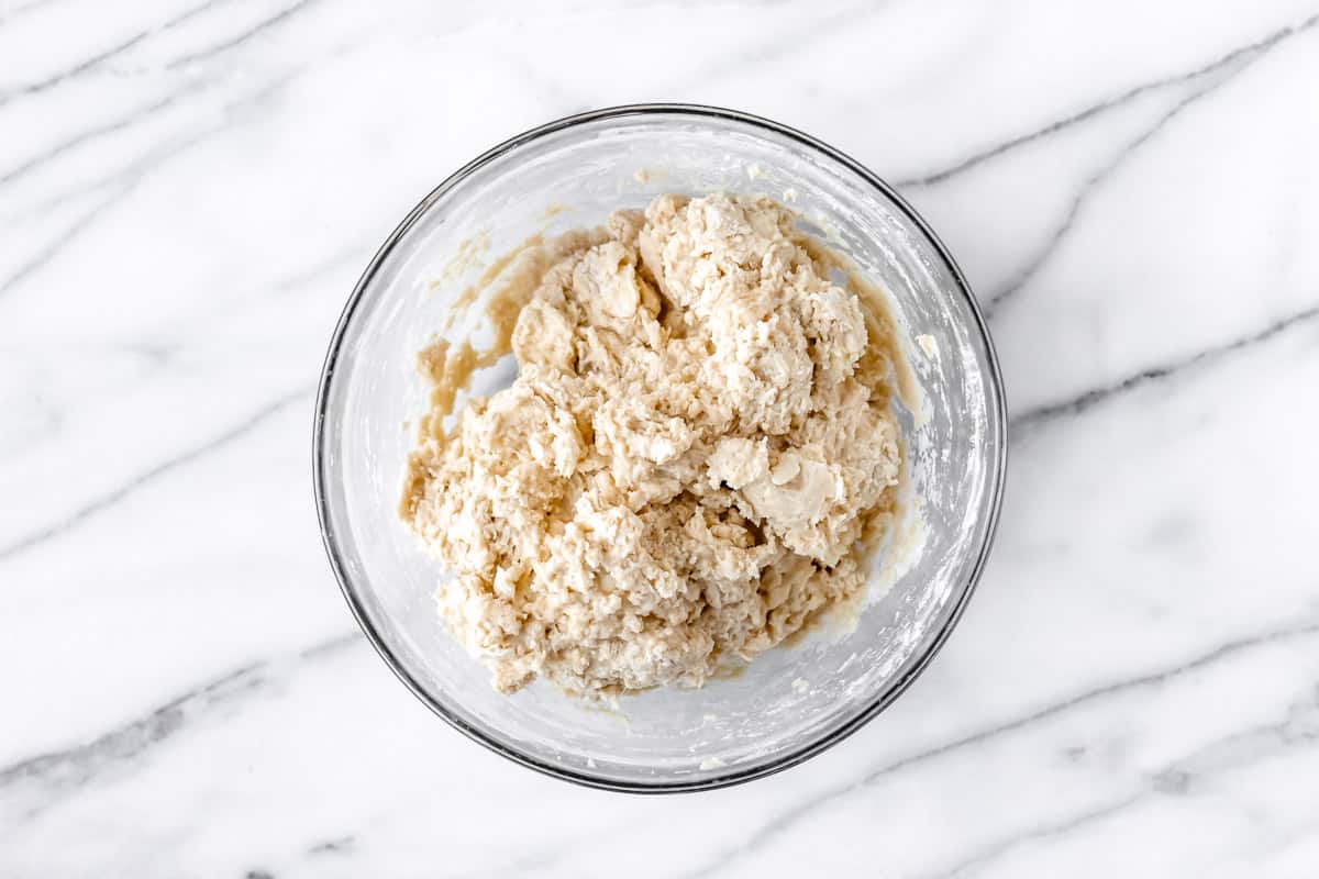 Drop biscuit dough in a glass bowl on a marble background.