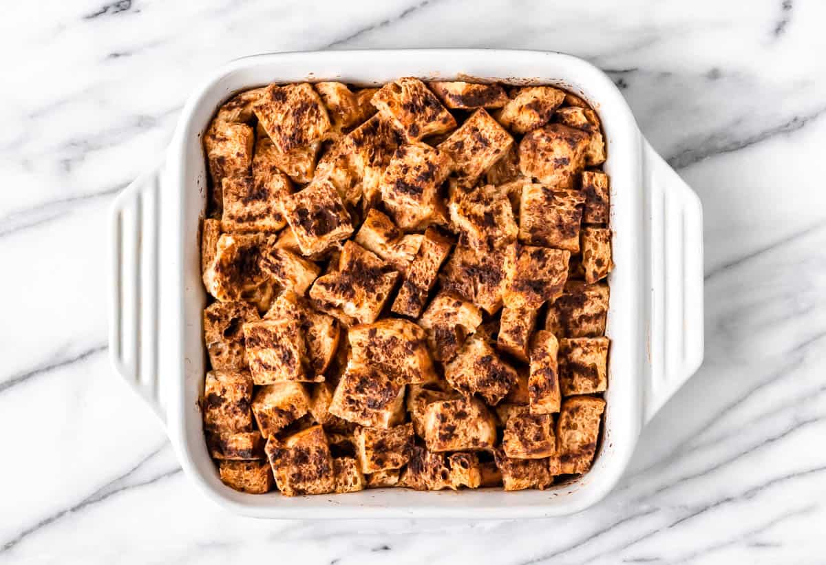 Overhead of a baked French Toast Casserole in a white casserole dish.