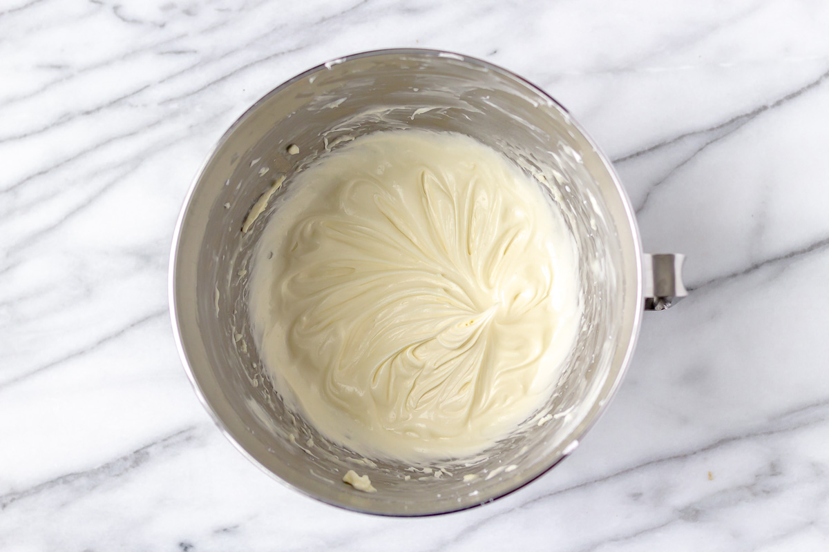 Vanilla cream cheese frosting in a silver mixing bowl.