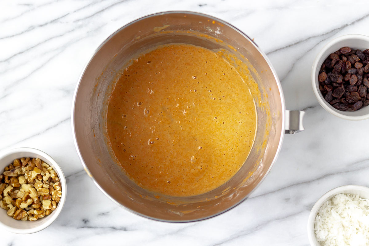 Carrot cake batter without any mix ins in a silver bowl.