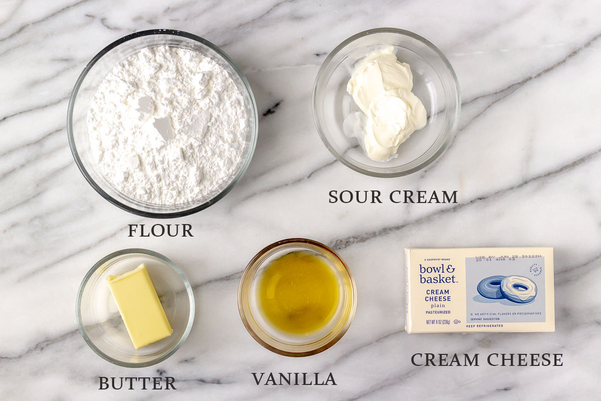 Ingredients to make vanilla cream cheese frosting on a marble background with text overlay.