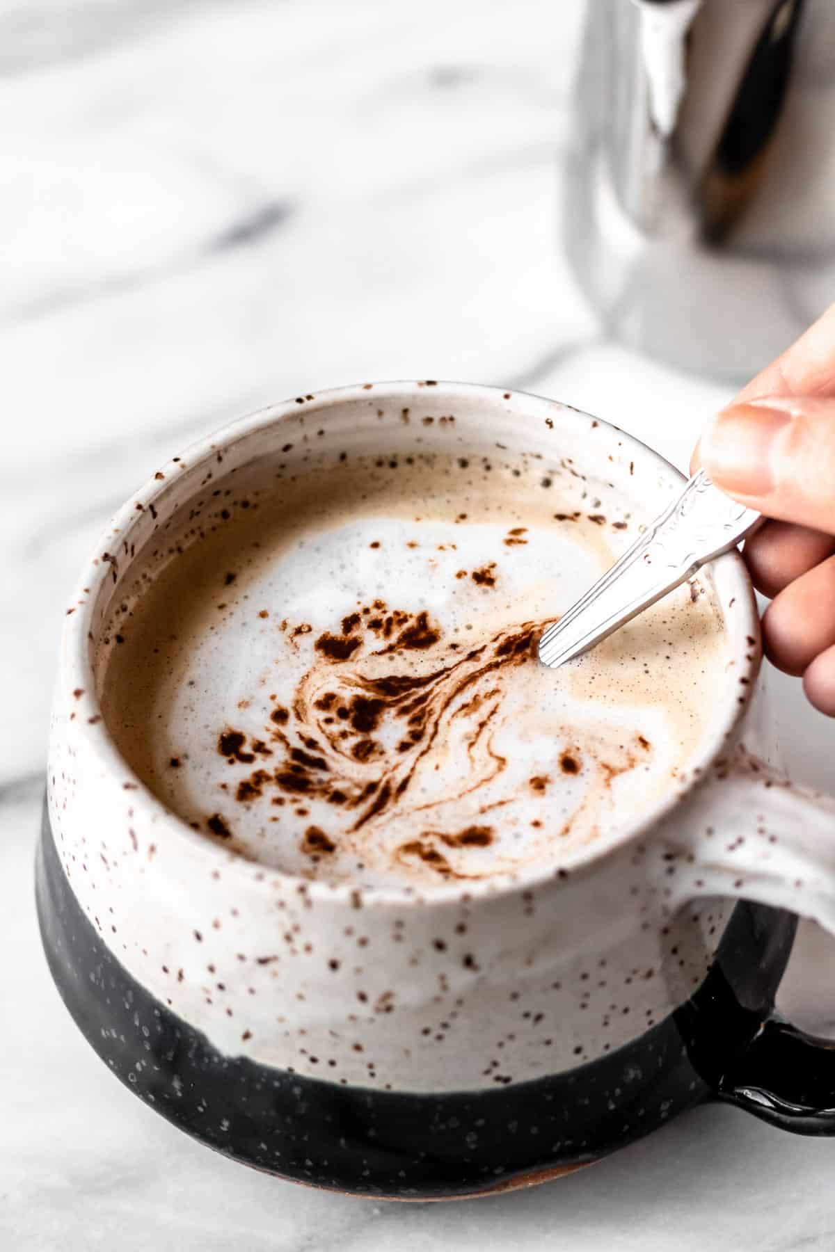 A Baileys Salted Caramel Mocha Latte with a spoon stirring it.