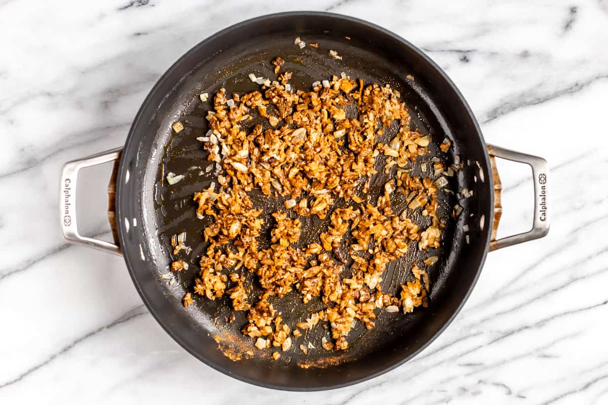 Finely diced onions and spices cooking in butter in a skillet.