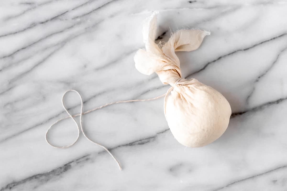 Cheese curds ties up in a ball of cheesecloth.