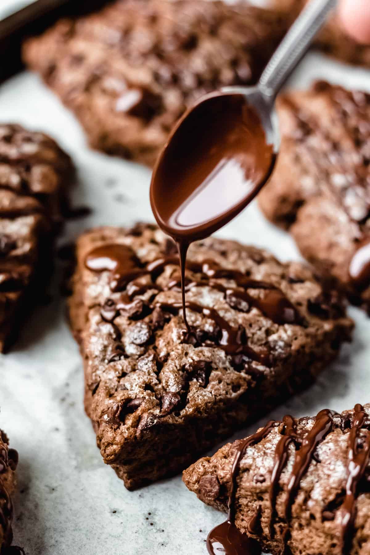 Melted chocolate being drizzled onto a chocolate scone.