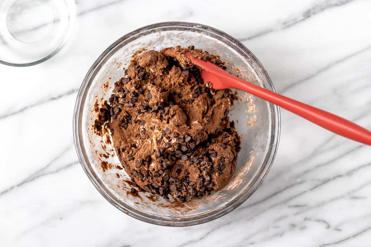Chocolate scones dough with mini chocolate chips mixed into it in a glass bowl.