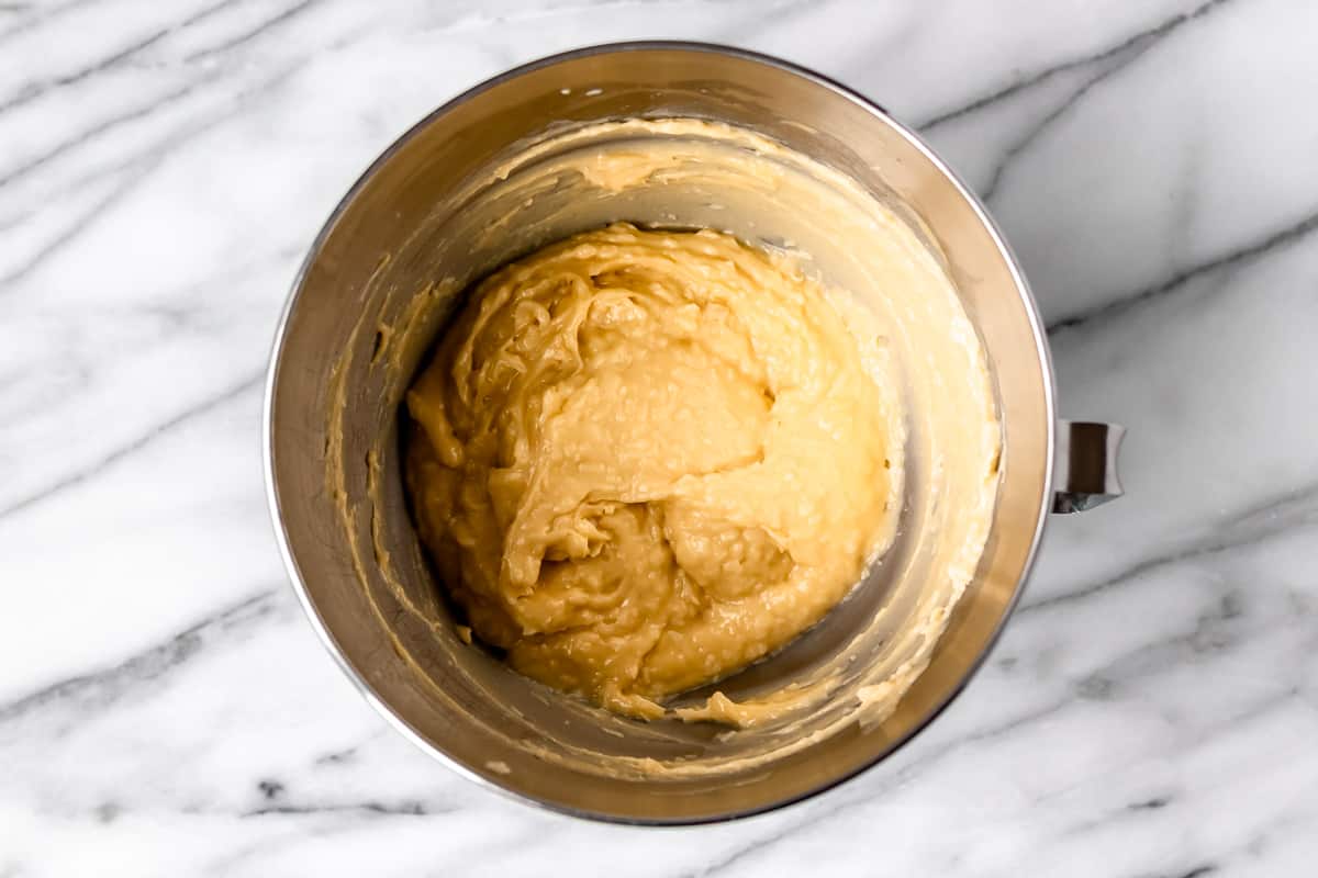 Pate a choux dough in a mixing bowl with cheese mixed into it.