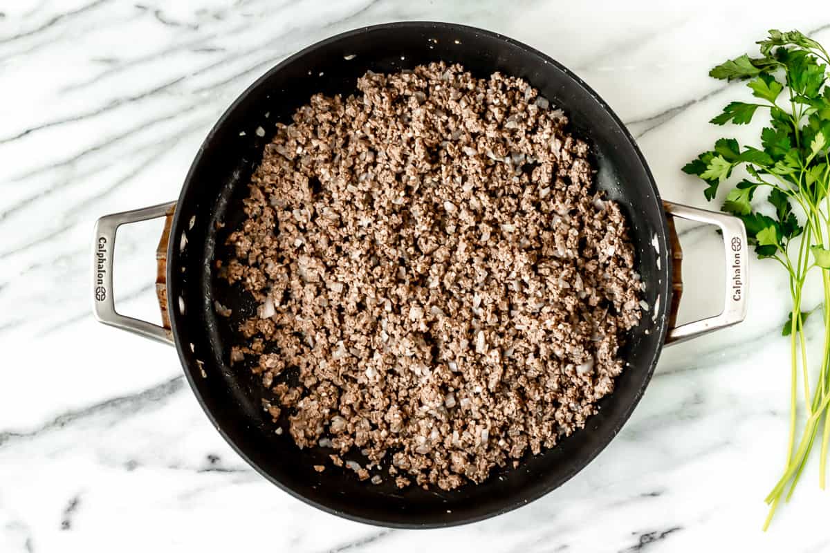 Ground beef cooking in a skillet.