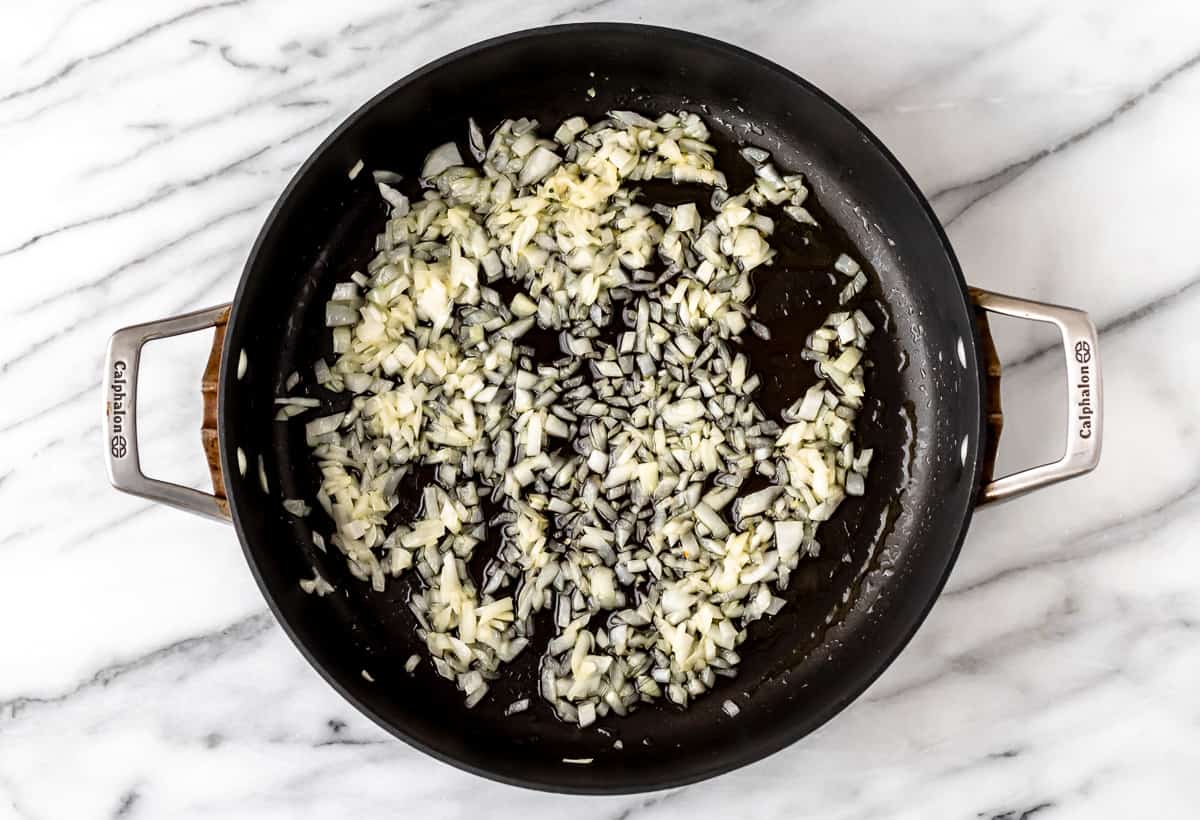 Onions cooking in butter in a skillet.