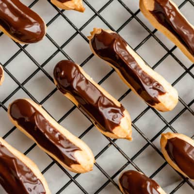 Overhead of mini chocolate eclairs on a cooling rack.