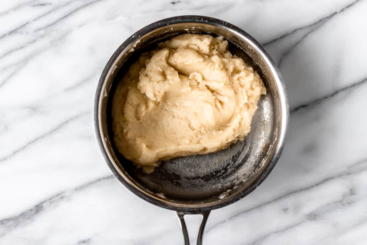 Pate a choux dough in a silver pot.