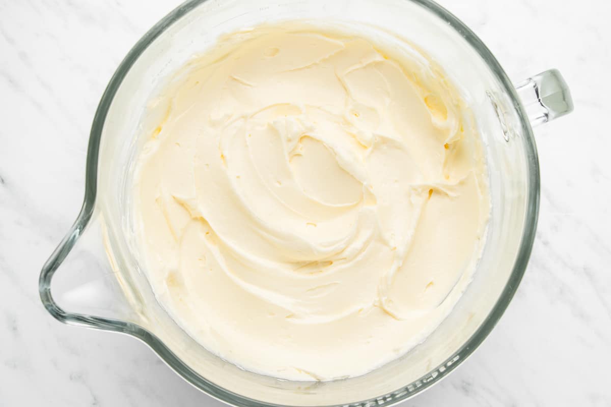 Cream cheese frosting in a glass bowl.
