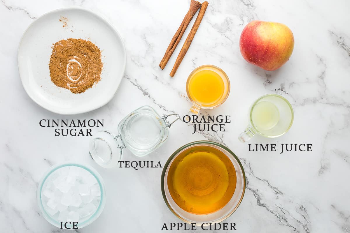 Ingredients to make an apple cider margarita with text overlay.