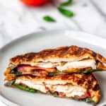 Chicken caprese panini on a plate with text overlay.