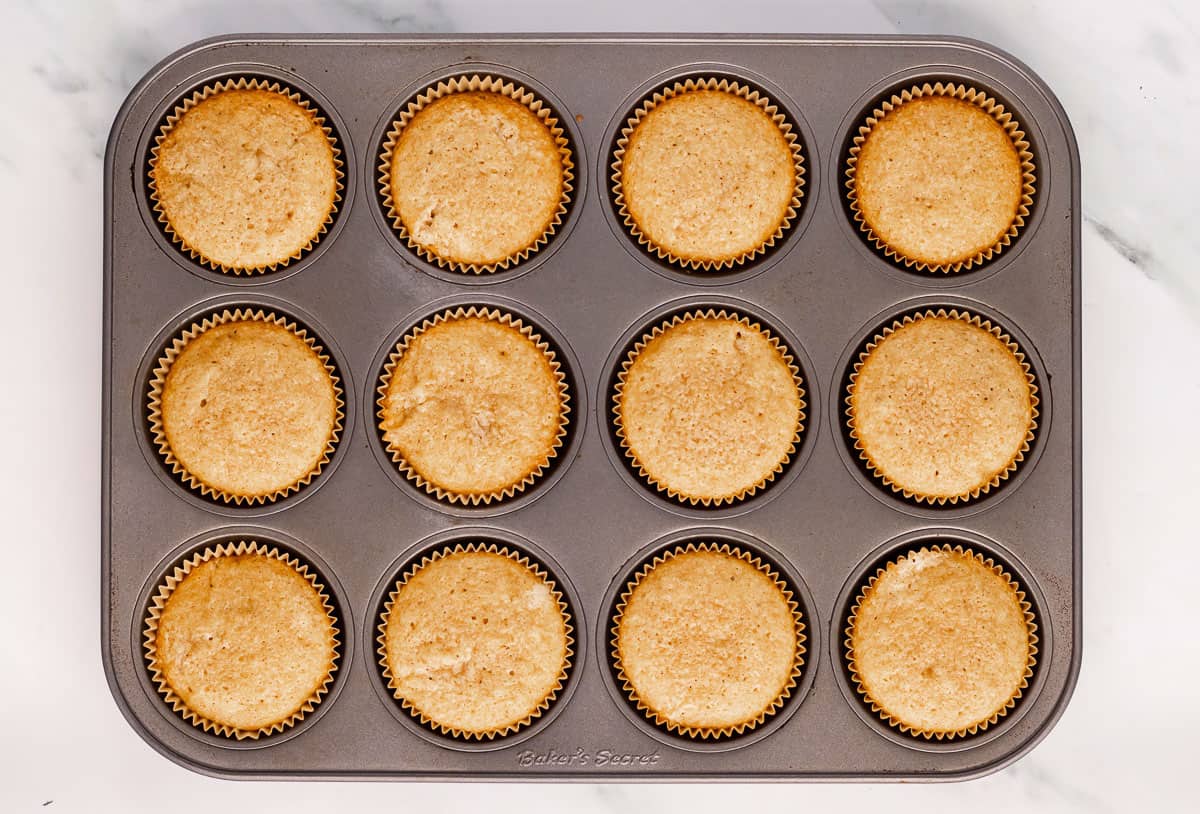 Baked eggnog cupcakes in a cupcake pan.