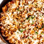 Ground beef pasta skillet with text overlay.