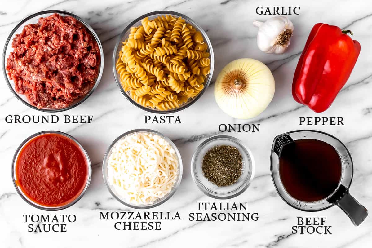Ingredients to make a ground beef pasta skillet on a marble background with text overlay.