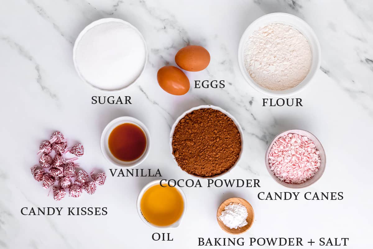 Ingredients to make chocolate peppermint kiss cookies in bowls with text overlay that states the name of each ingredient.
