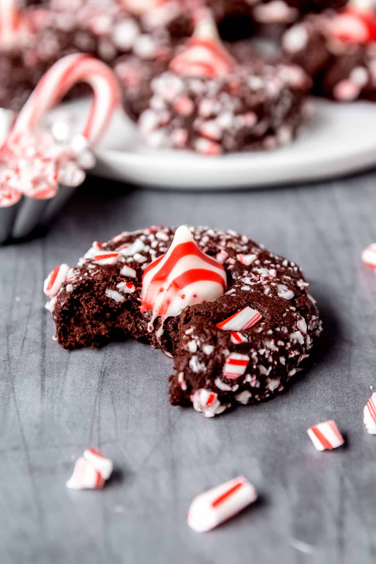 Close up of a chocolate peppermint kiss cookie with a bite taken out of it.