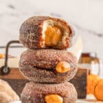 A stack of pumpkin filled donuts with text overlay.