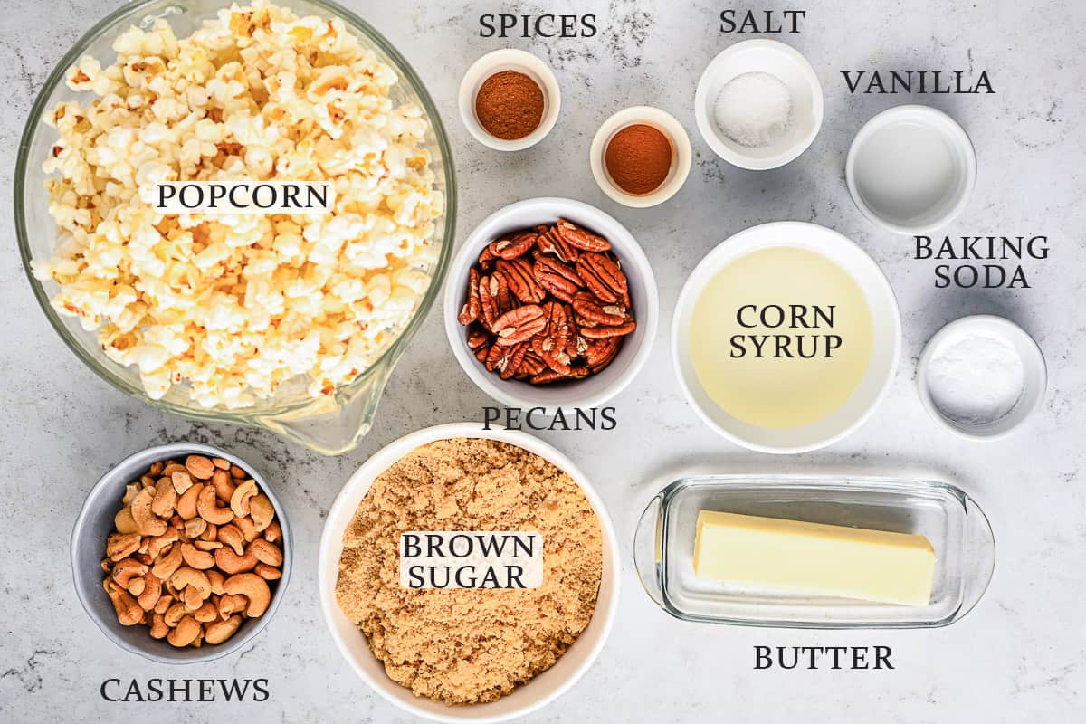 Ingredients needed to make pumpkin spice caramel corn on a marble background with labels.