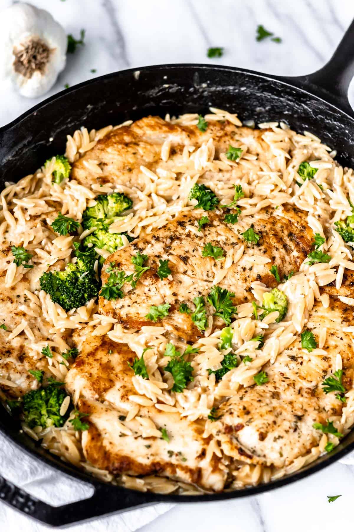 Close up of a creamy parmesan chicken and orzo skillet.