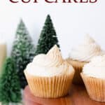 Eggnog cupcakes on a wood stand with faux trees in the background and text overlay.