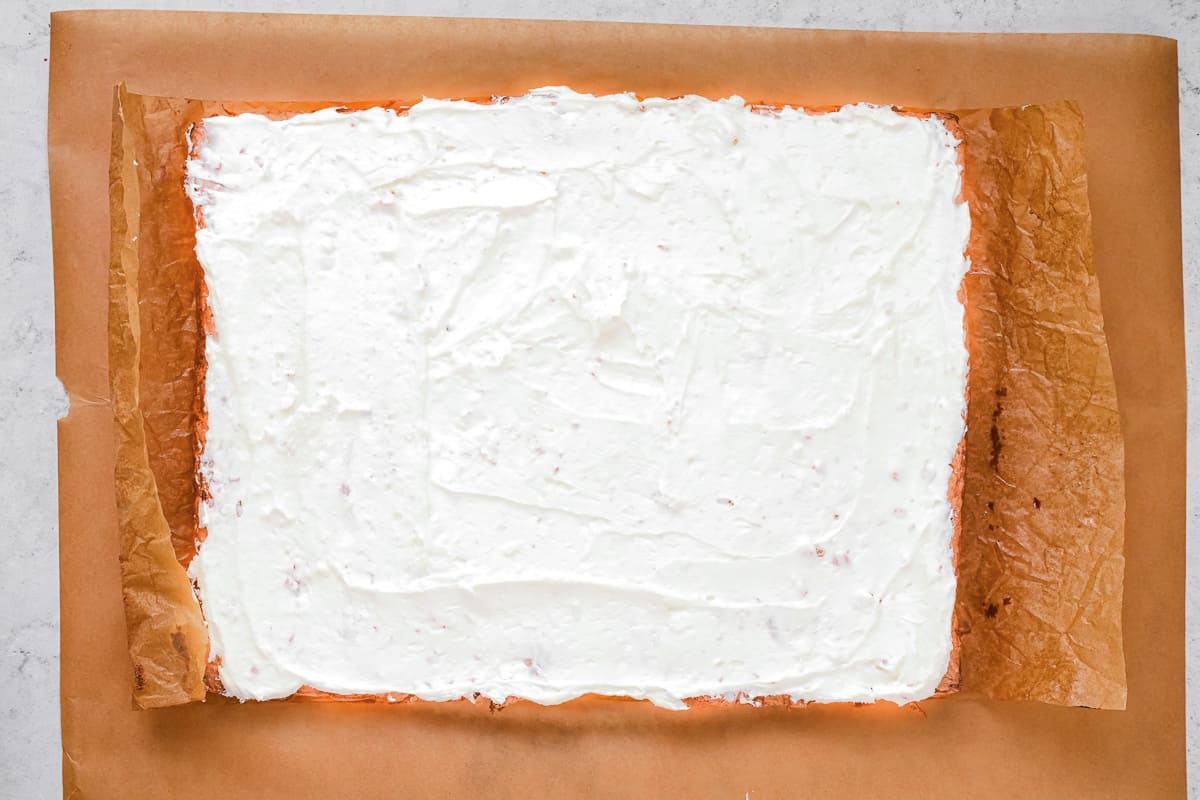 A frosted gingerbread sheet cake on parchment paper.