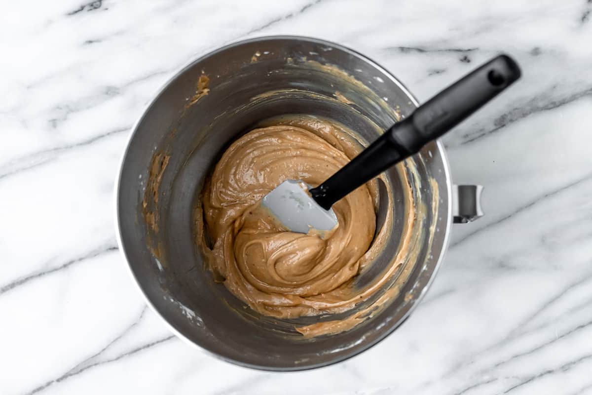 Peanut butter buttercream in a silver bowl with a spatula.
