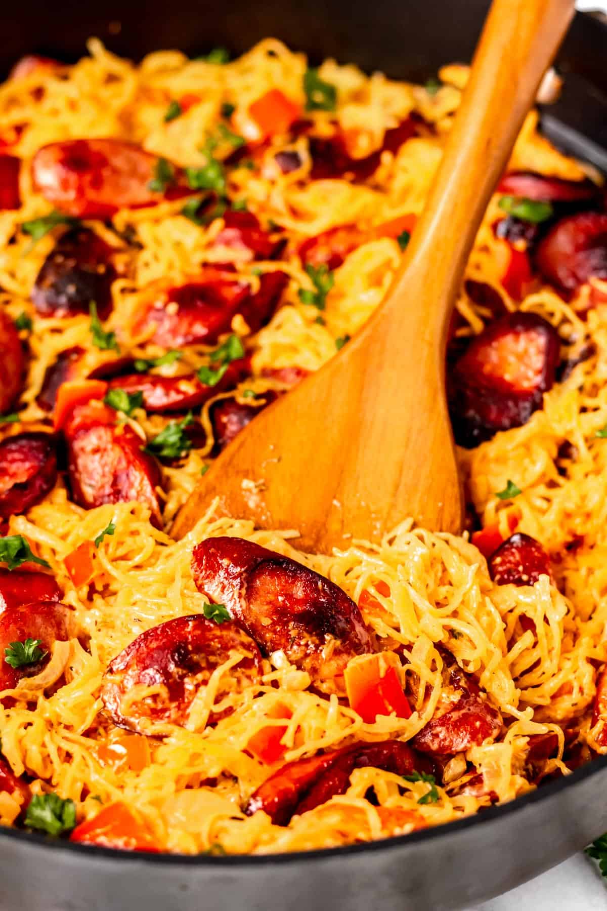 Close up of a wood server lifting up some of the Italian Sausage Spaghetti Squash.