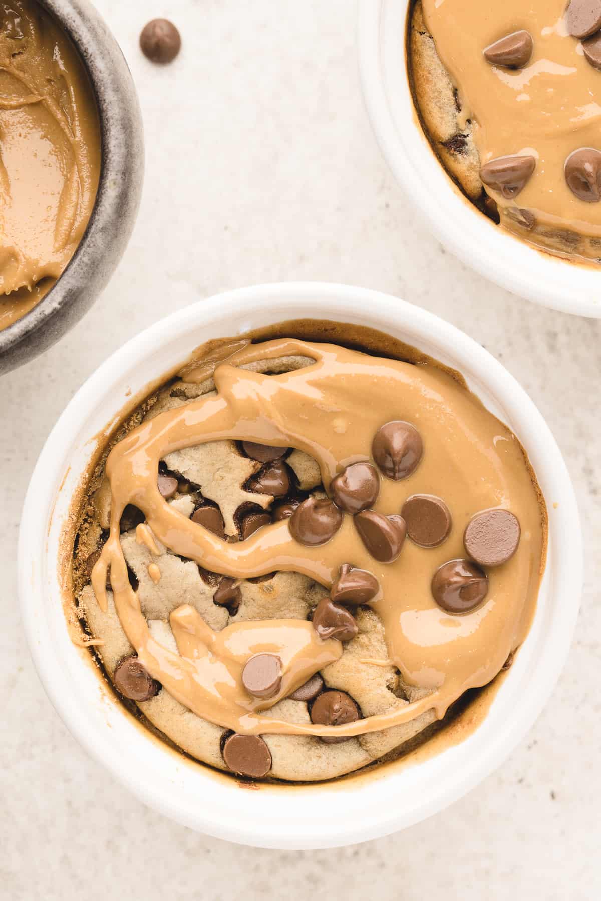 Overhead of a blended baked oatmeal in a ramekin topped with peanut butter and chocolate chips.
