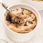 A spoonful of peanut butter chocolate blended baked oats being lifted up from a ramekin.