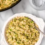 A white bowl full of cheesy broccoli cauliflower rice with text overlay that says cheesy broccoli cauliflower rice.
