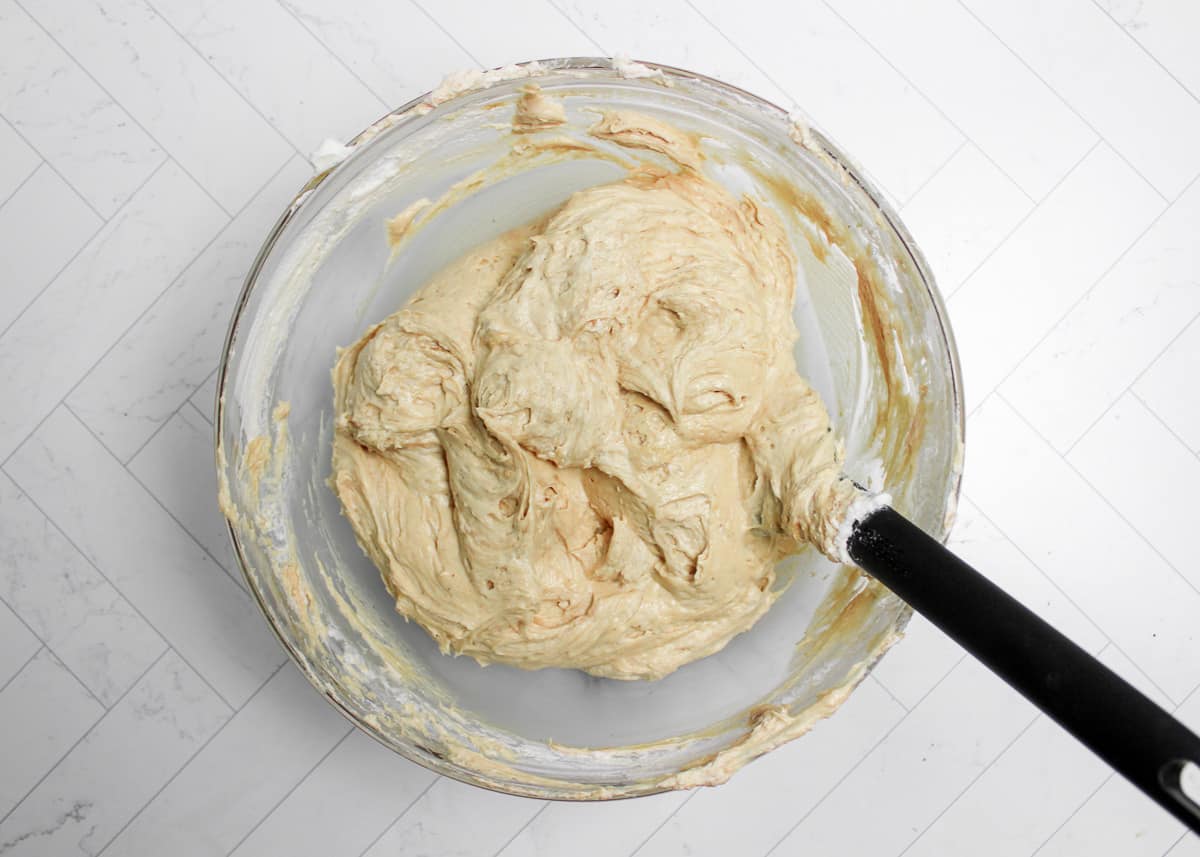 Peanut butter pie batter in a glass bowl with a spatula.