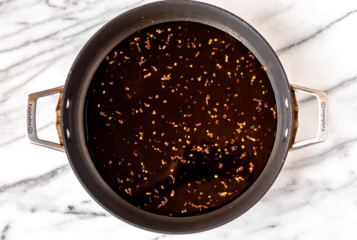 Mongolian sauce in a black skillet over a marble background.