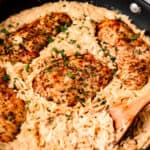 Parmesan Chicken Orzo in a skillet with a wood spoon with text overlay.