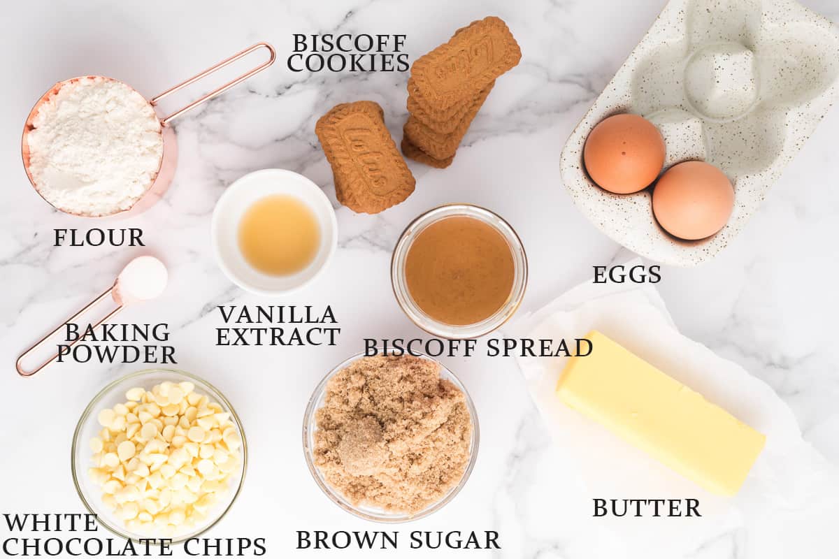 Ingredients needed to make Biscoff blondies on a white surface with text overlay.