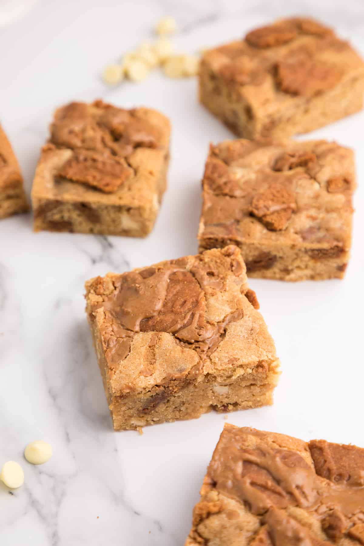 Close up of Biscoff blondies on a white surface.