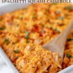 A spoon lifting up some buffalo chicken spaghetti squash casserole in the baking dish with text overlay.