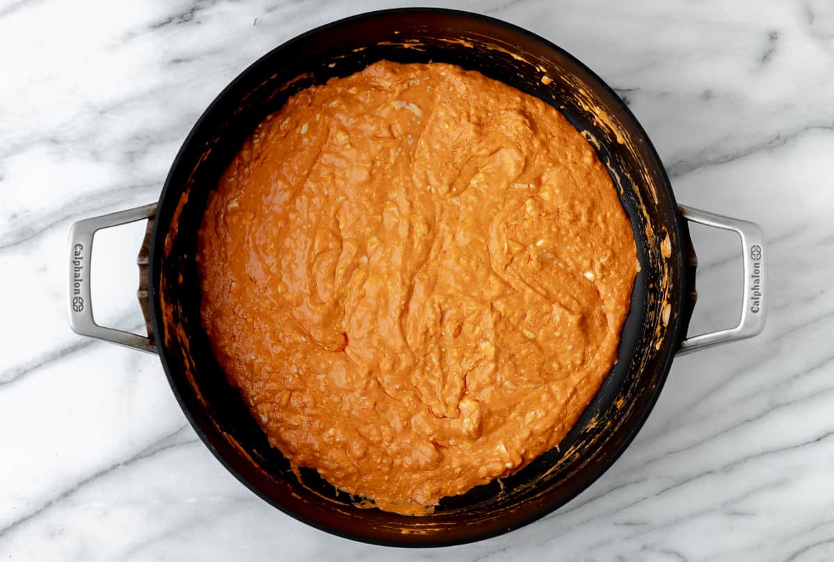 Cream cheese buffalo sauce in a black skillet.