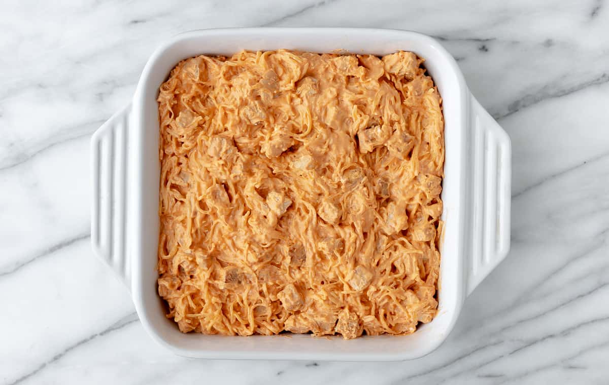 Buffalo chicken and spaghetti squash in a white, square casserole dish.