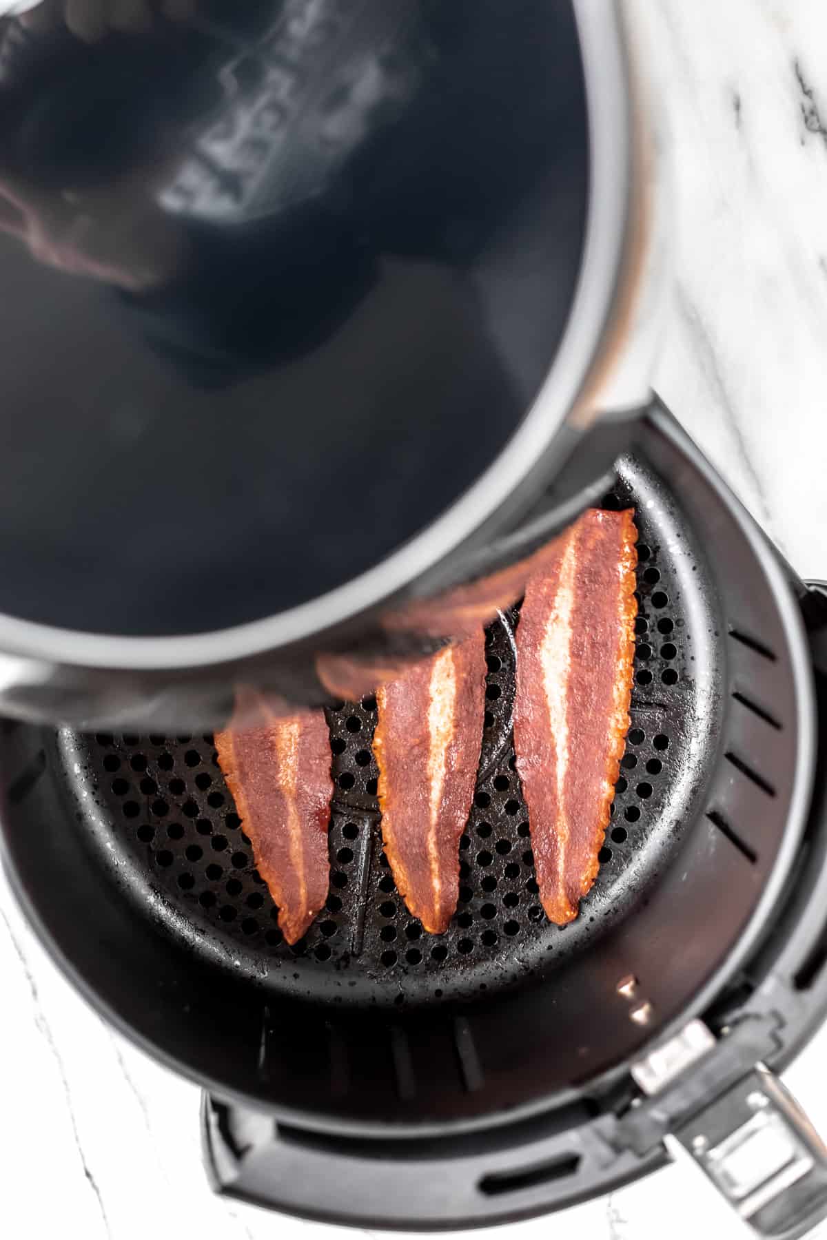 Cooked turkey bacon shown in a partially opened air fry basket.