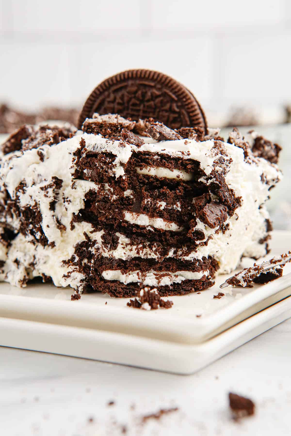 A slice of Oreo Icebox Cake with the cake cut into showing Oreo cookies inside.