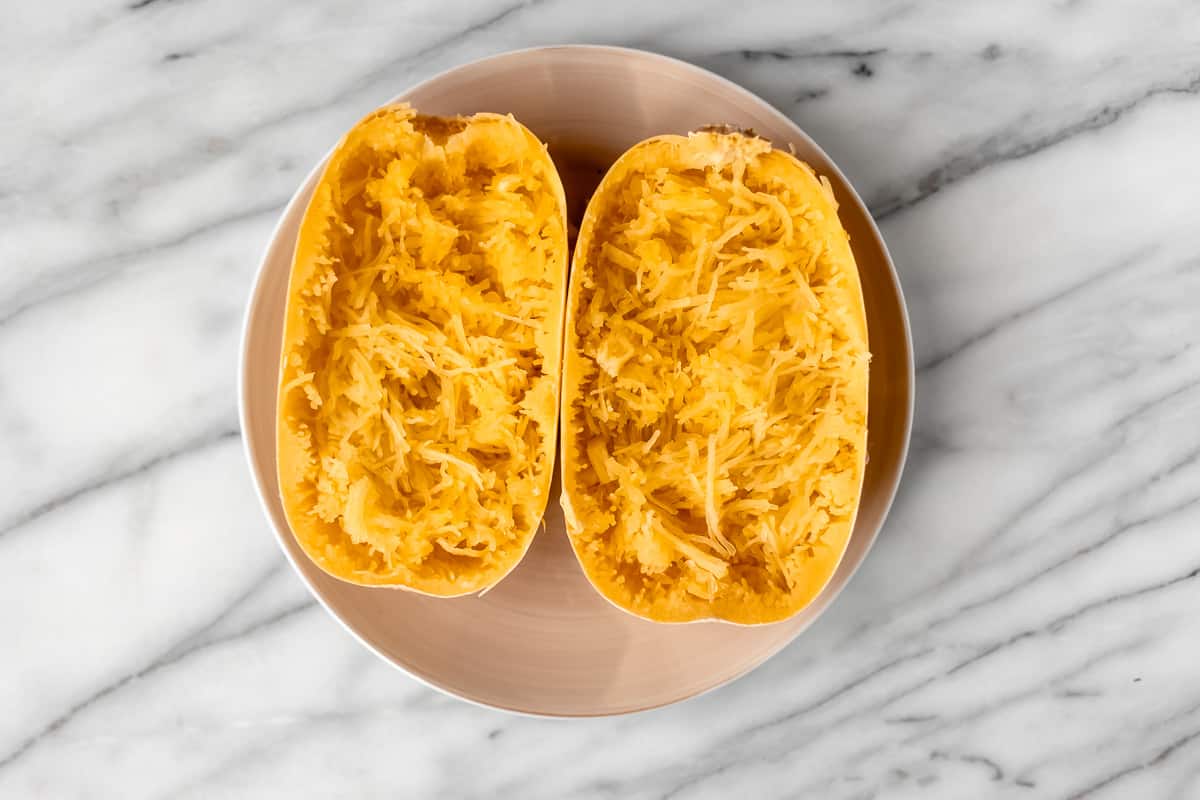 Two halves of a spaghetti squash with the flesh scraped to look like spaghetti.